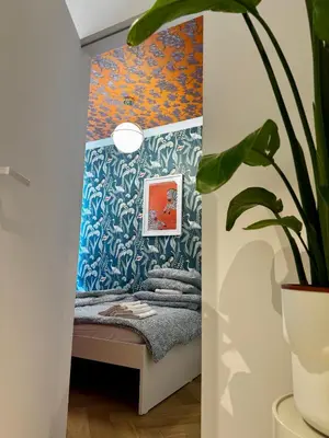 a room with a bed and a plant at Piltza House in Kraków