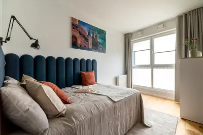 a bedroom with a large bed with a blue headboard at Central Luminis Comfort Kraków 2 in Kraków