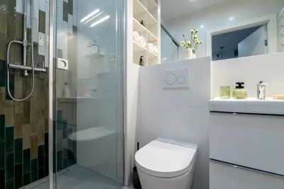 a white bathroom with a toilet and a shower at Central Luminis Comfort Kraków 2 in Kraków