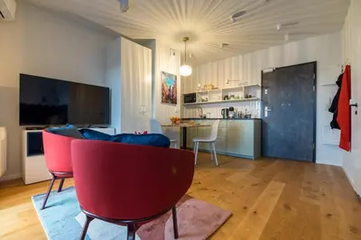 a living room with a couch and a kitchen at Central Luminis Comfort Kraków 2 in Kraków