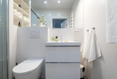 a white bathroom with a toilet and a sink at Central Luminis Comfort Kraków 2 in Kraków