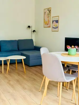 a living room with a blue couch and a table at Best Rest Kraków in Kraków