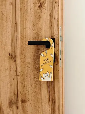 a wooden door with a dog tag on it at Best Rest Kraków in Kraków