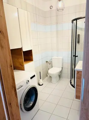 a washing machine in a bathroom with a toilet at Best Rest Kraków in Kraków