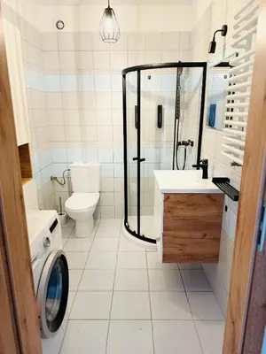 a bathroom with a shower and a toilet and a sink at Best Rest Kraków in Kraków