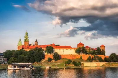 a castle on a hill next to a body of water at Apartament Green Old Town Krakow in Kraków