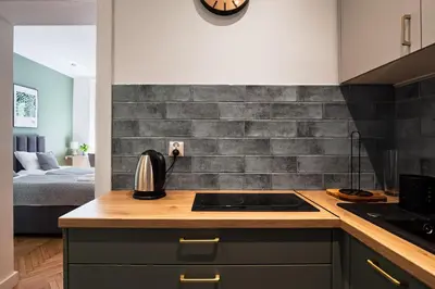 a kitchen with a stove top oven next to a bed at Apartament Green Old Town Krakow in Kraków