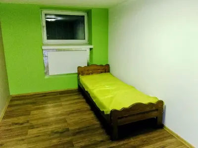 a green room with a bed and a window at Budget & Cosy APART in Kraków