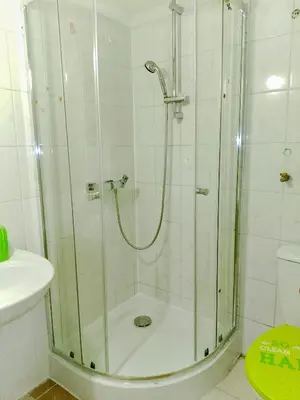 a shower with a glass door in a bathroom at Budget & Cosy APART in Kraków