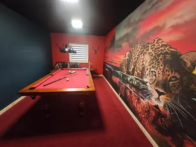 a room with a pool table and a painting of a leopard at Chatka Przytulasek in Męcina