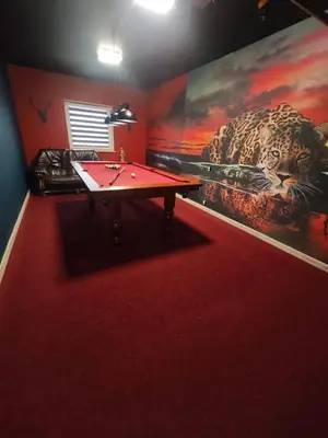 a room with a table and a painting of a leopard at Chatka Przytulasek in Męcina