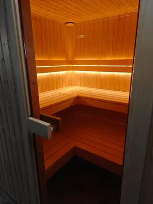 a small wooden sauna with a light in it at Chatka Przytulasek in Męcina