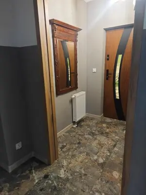 a hallway with a door and a mirror and a room at Chatka Przytulasek in Męcina