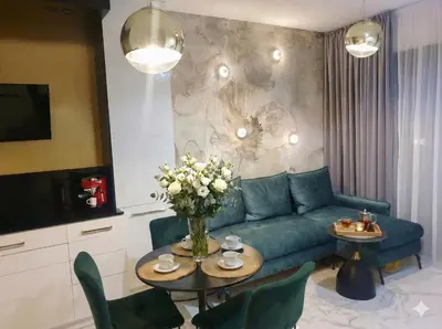 a living room with a blue couch and a table with flowers at Apartment Cracow Old Town in Kraków