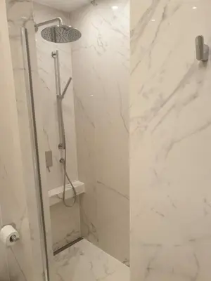 a bathroom with a shower with white marble at Apartment Cracow Old Town in Kraków