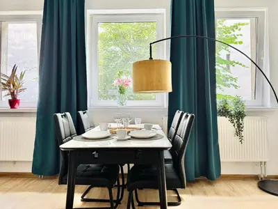 a dining room table with chairs and a lamp at GREEN APARTMENTS #Kazimierz, building C in Kraków