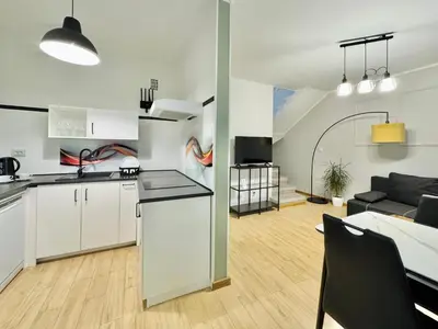 a kitchen and living room with white cabinets at GREEN APARTMENTS #Kazimierz, building C in Kraków