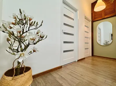 a vase with white flowers in a hallway at GREEN APARTMENTS #Kazimierz, building C in Kraków