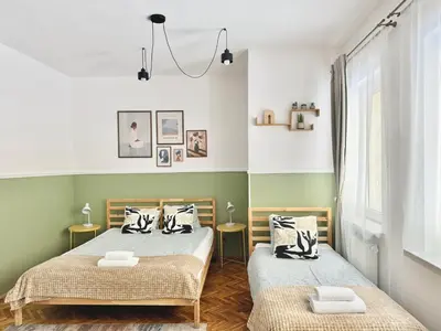 two beds in a room with green and white walls at GREEN APARTMENTS #Kazimierz, building C in Kraków