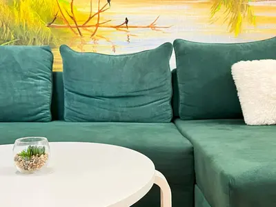 a green couch with a white table and a bowl on it at Premium & Quiet Apartment next to Main Square in Kraków