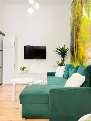 a living room with a green couch and a tv at Premium & Quiet Apartment next to Main Square in Kraków