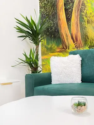a living room with a green couch and a painting at Premium & Quiet Apartment next to Main Square in Kraków