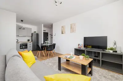 a living room with a couch and a table at Wybickiego Stylish Apartments with Parking and Air Conditioning in Cracow by Noclegi Renters in Kraków