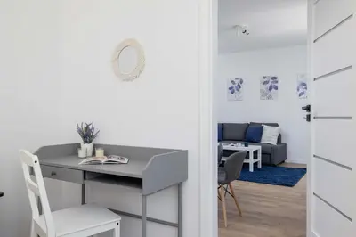 a room with a desk and a table and chairs at Wybickiego Stylish Apartments with Parking and Air Conditioning in Cracow by Noclegi Renters in Kraków