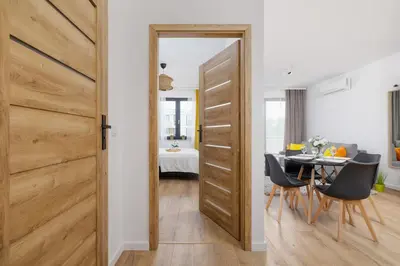 a door leading into a dining room with a table at Wybickiego Stylish Apartments with Parking and Air Conditioning in Cracow by Noclegi Renters in Kraków