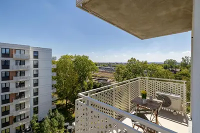 a balcony with a table and chairs and a building at Wybickiego Stylish Apartments with Parking and Air Conditioning in Cracow by Noclegi Renters in Kraków