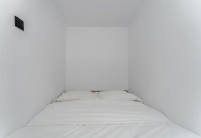 a bed in a room with a white wall at Pleszowska Urban Elegance Apartments by BookingHost in Kraków