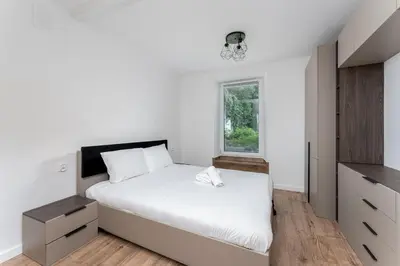 a bedroom with a white bed and a window at Pleszowska Urban Elegance Apartments by BookingHost in Kraków