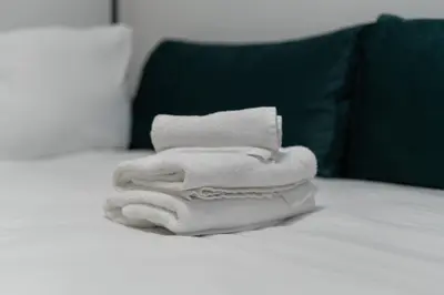 a pile of towels sitting on top of a bed at Pleszowska Urban Elegance Apartments by BookingHost in Kraków