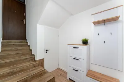 a hallway with white cabinets and a staircase at Pleszowska Urban Elegance Apartments by BookingHost in Kraków