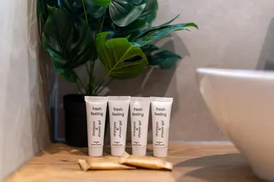 a group of four tubes of toothpaste sitting on a table with a plant at Pleszowska Urban Elegance Apartments by BookingHost in Kraków