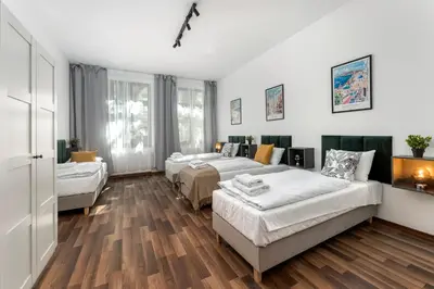a bedroom with two beds and a living room at Hala Targowa Apartments in Kraków
