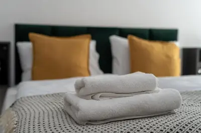 a pile of towels sitting on top of a bed at Hala Targowa Apartments in Kraków