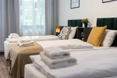 a hotel room with two beds with towels on them at Hala Targowa Apartments in Kraków