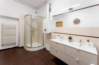 a bathroom with two sinks and a shower at Hala Targowa Apartments in Kraków