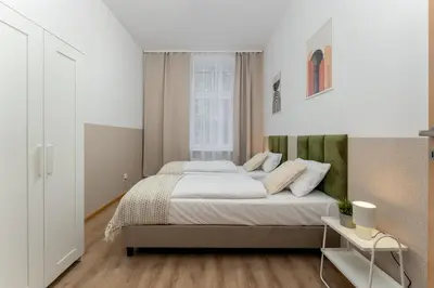 a bedroom with a large bed and a window at Hala Targowa Apartments in Kraków