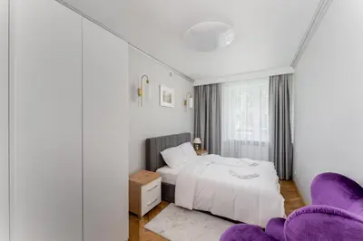 a bedroom with a bed and two purple chairs at Osiedle Willowe Vintage Chic Apartment by BookingHost in Kraków