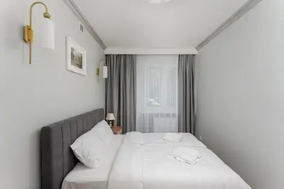 a bedroom with a white bed and a window at Osiedle Willowe Vintage Chic Apartment by BookingHost in Kraków