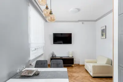 a white living room with a table and a couch at Osiedle Willowe Vintage Chic Apartment by BookingHost in Kraków