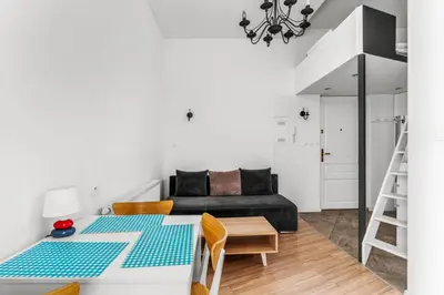a living room with a table and a couch at Morsztynowska Studio with Mezzanine by BookingHost in Kraków