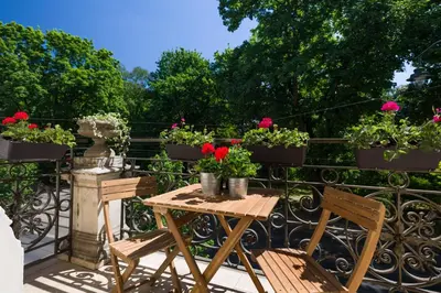 a table and chairs on a balcony with flowers at Vanilla Apartments - 3 spacious apartments 5min to Main Square in Kraków