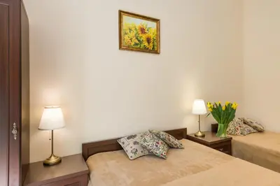 a bedroom with two beds and a picture on the wall at Vanilla Apartments - 3 spacious apartments 5min to Main Square in Kraków