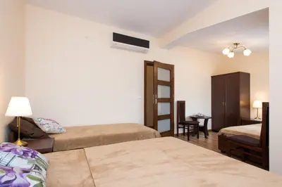 a hotel room with two beds and a desk at Vanilla Apartments - 3 spacious apartments 5min to Main Square in Kraków