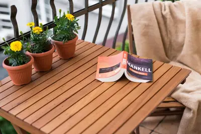 a wooden table with potted plants and a book on it at Vanilla Apartments - 3 spacious apartments 5min to Main Square in Kraków
