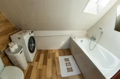 a bathroom with a sink and a washing machine at Dom w Chomranicach-domek grillowy in Chomranice