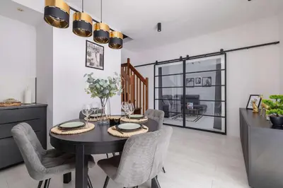 a dining room with a black table and chairs at Spacious Apartment in Wieliczka with AC & Parking in Wieliczka